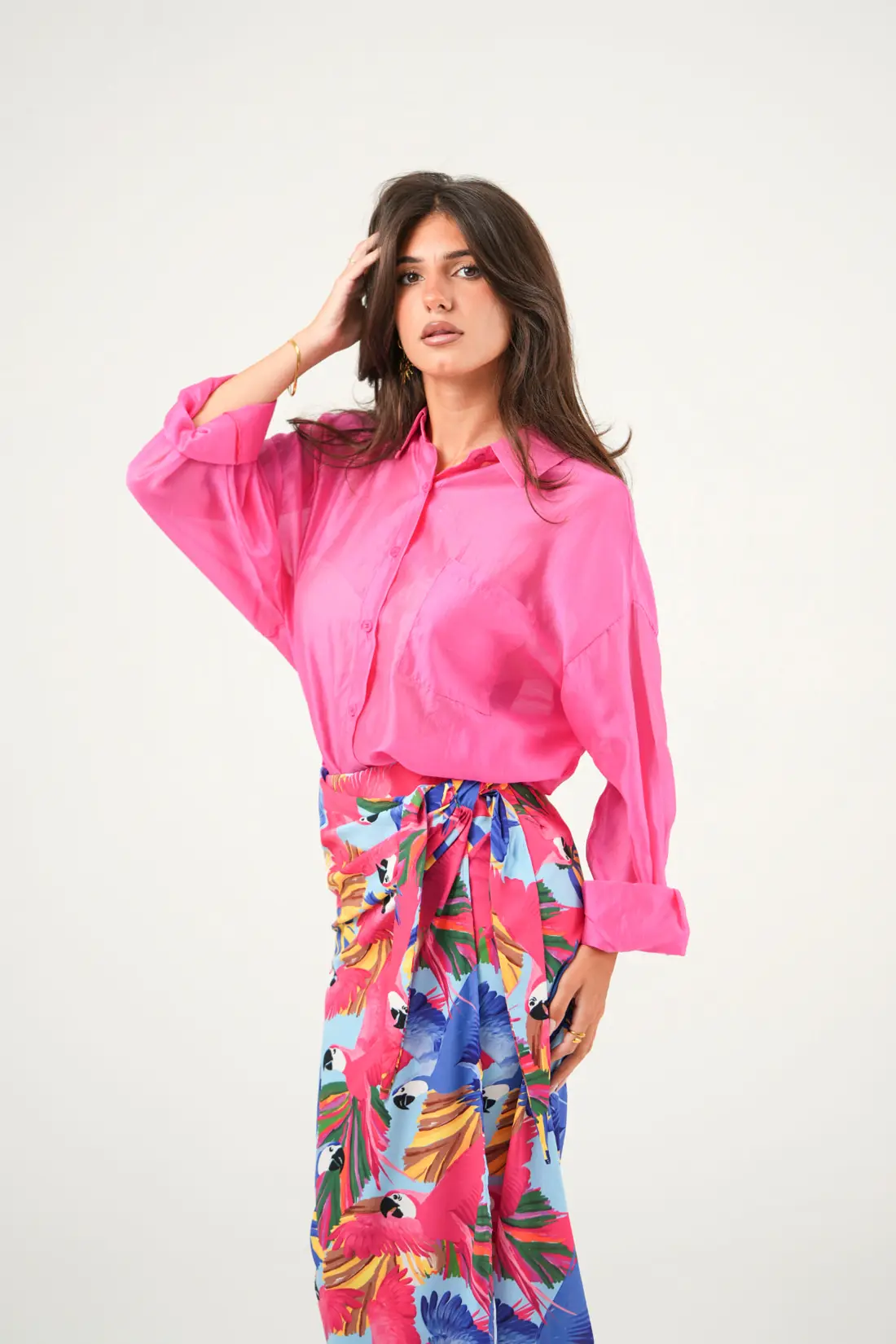 Shooting moda: modella con camicia fucsia su fondale chiaro